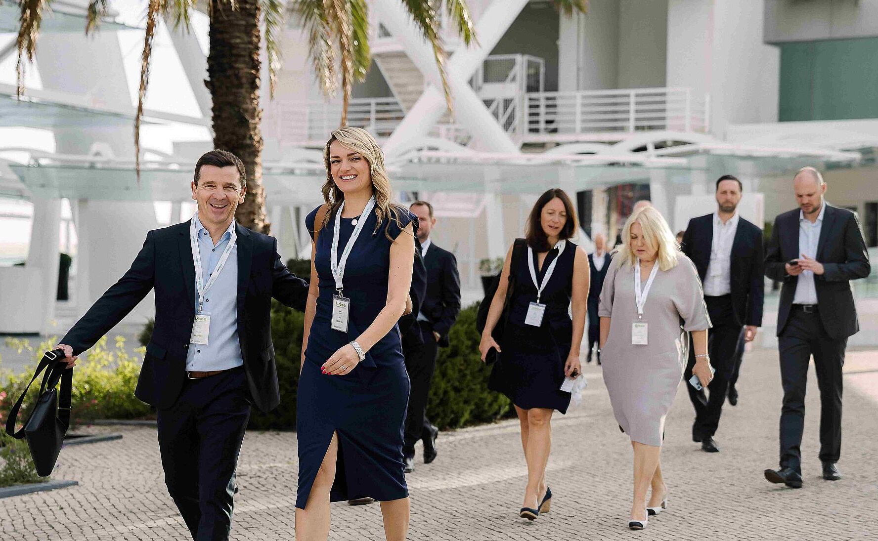 People walking in front of a big white building